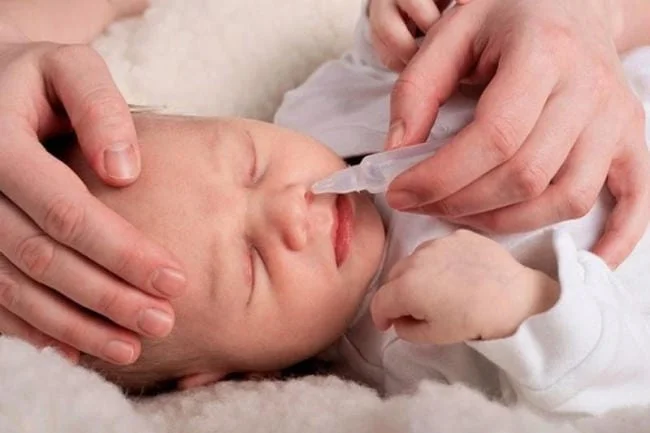 Nhỏ nước muối trước khi dùng ống bơm hút mũi cho trẻ sơ sinh