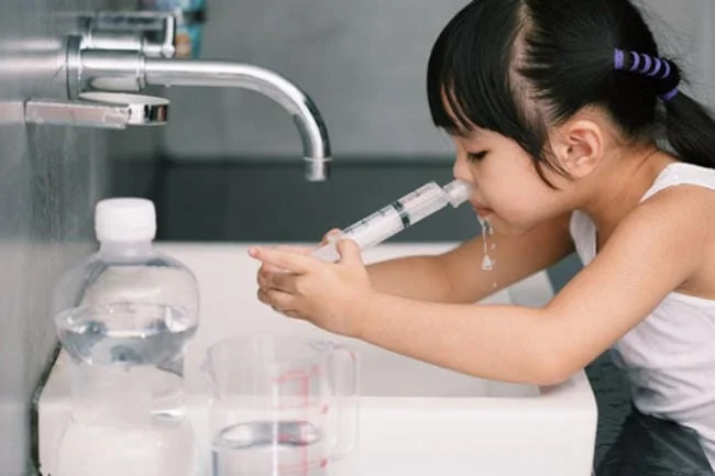 Rửa mũi cho bé bằng nước muối sinh lý
