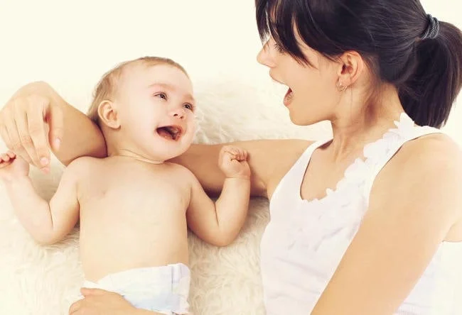 Bé 5 tháng thích ê a nói chuyện với cha mẹ