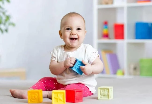 Bé 7 tháng tuổi rất thích chơi với các đồ vật nhiều màu sắc