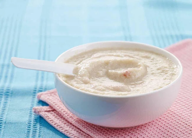 Mẹ có thể nấu cháo xay nhuyễn và thêm sữa bột để cho con ăn dặm